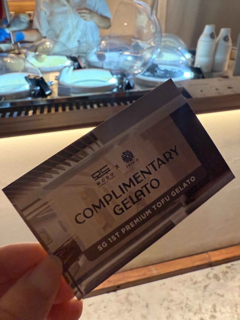 MODU x Tofu G complimentary gelato voucher held in front of the Tofu G Gelato counter at Mandarin Gallery