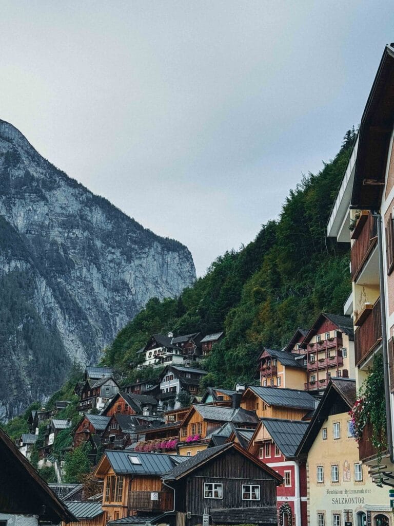 A dense cluster of traditional wooden and colorful houses built on the steep hillside overlooking Lake Hallstatt, showcasing the narrow, terraced structure of the village.
