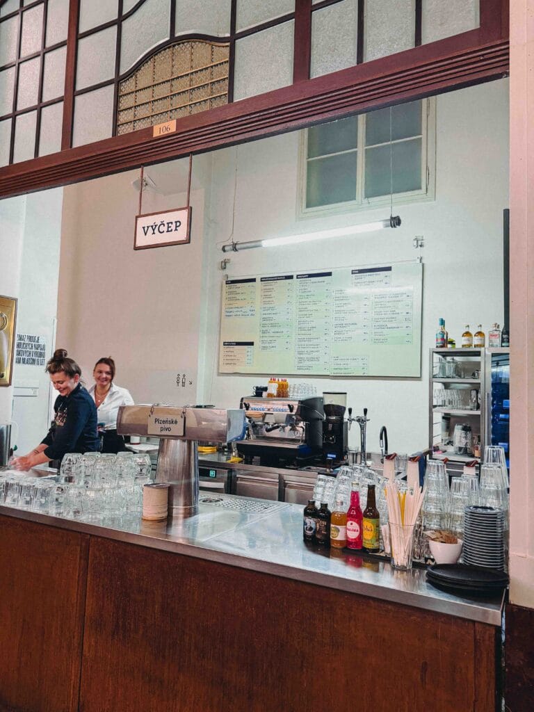 The busy drink ordering station at Kantýna where bartenders pour fresh Czech beer and soft drinks.