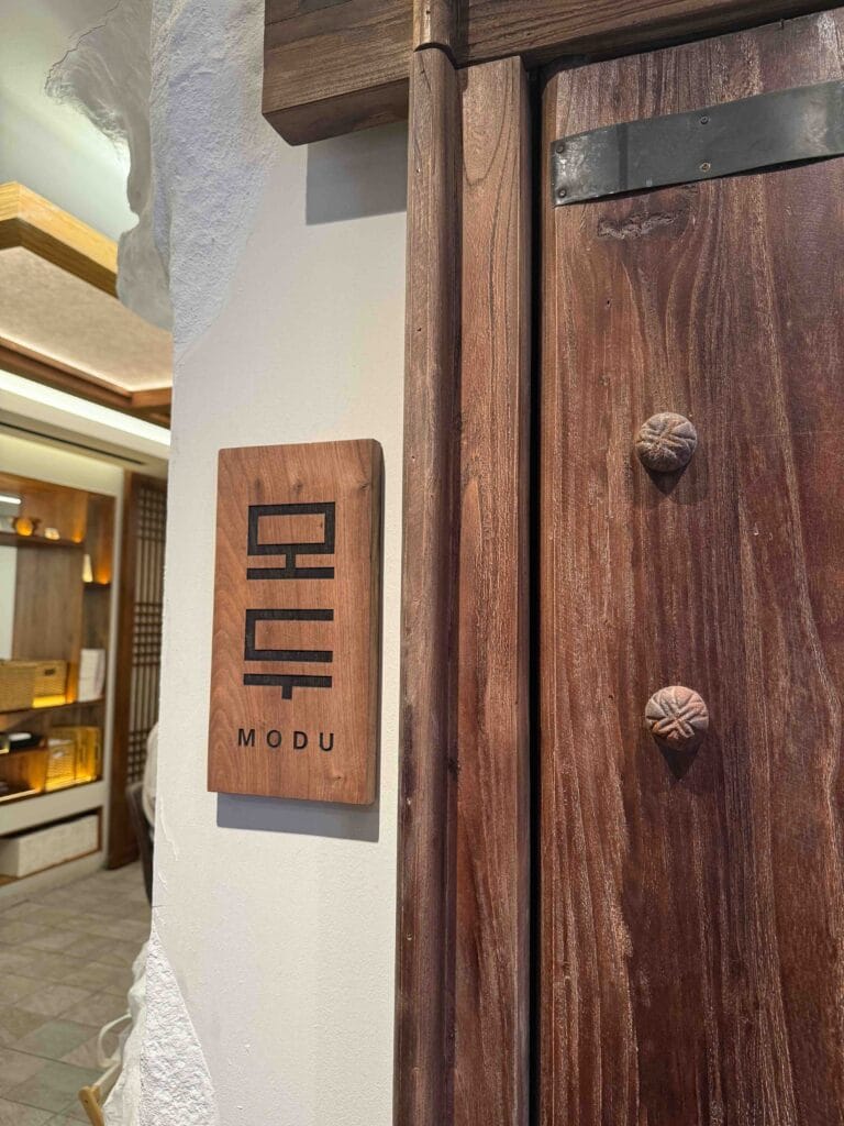 Wooden MODU sign in Korean lettering beside the entrance door of MODU Samgyetang in Mandarin Gallery