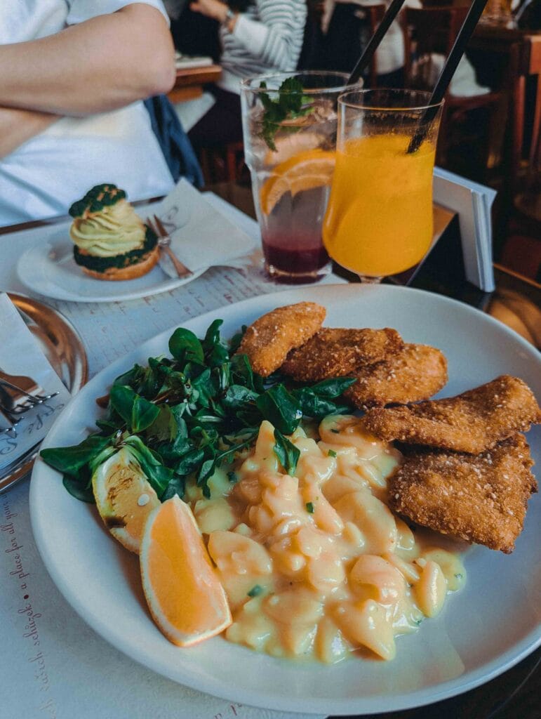 A plate featuring five pieces of crispy fried turkey chop served alongside Viennese potato salad and lamb's lettuce dressed with pumpkin seed oil.