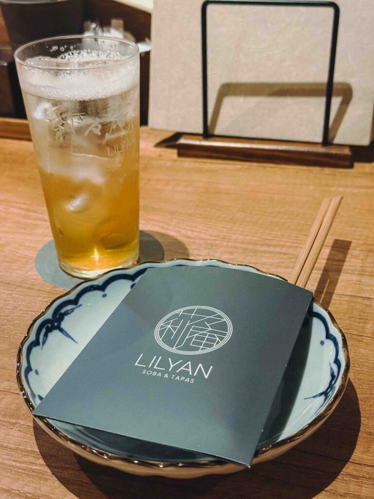 LILYAN Soba & Tapas menu card with ume plum alcohol drink and chopsticks on wooden table