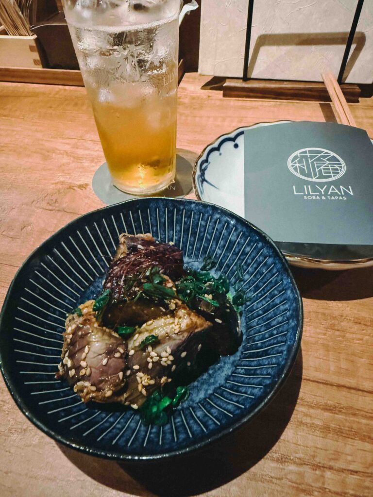 Nasu fried eggplant with spicy sauce served in a blue ceramic bowl at LILYAN Singapore