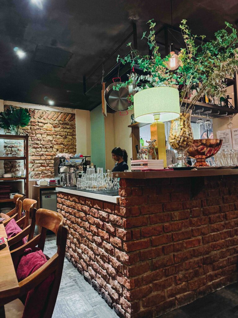 Brick bar counter at My Little Spanish Place Singapore with hanging plants and wine glasses