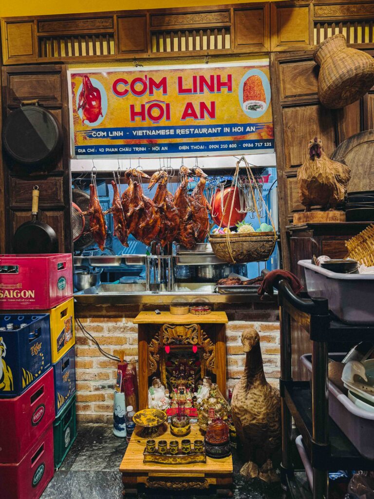 Cơm Linh Hội An restaurant exterior with rows of lacquered roasted ducks hanging in the open kitchen window on Phan Chu Trinh Street