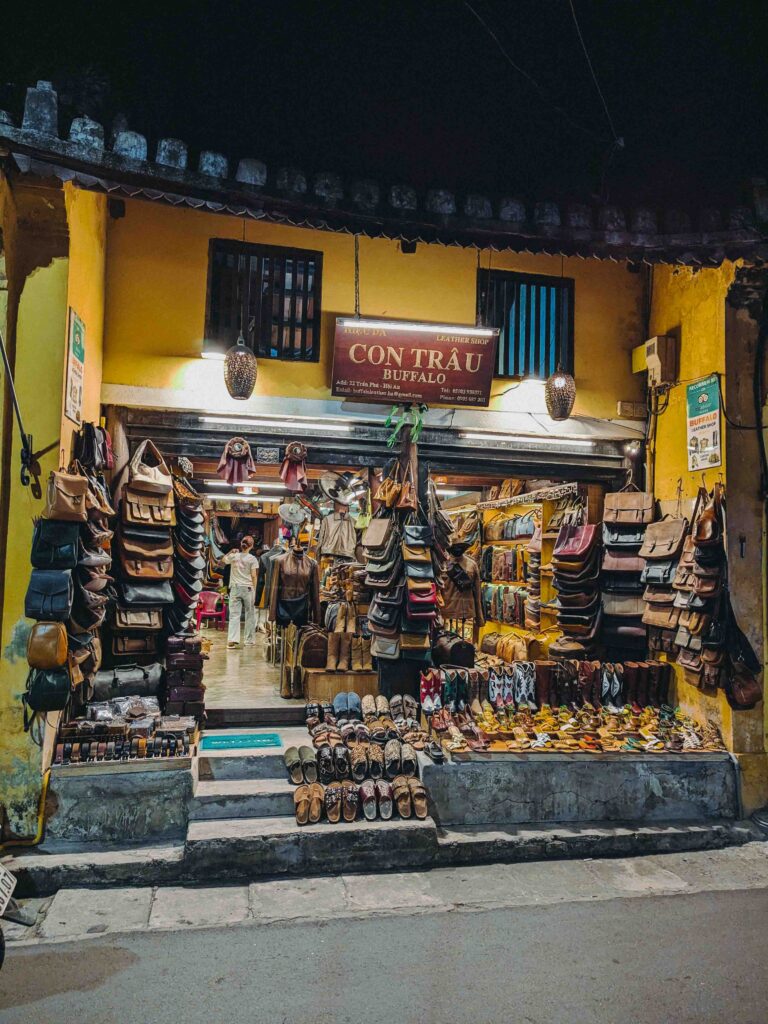 Con Trau Buffalo leather shop in Hoi An Old Town at night displaying handmade leather bags shoes and accessories