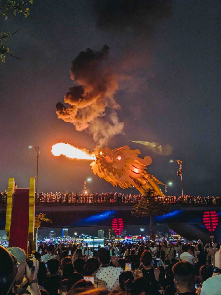 Dragon Bridge Da Nang breathing fire during the weekend night show with crowds watching below