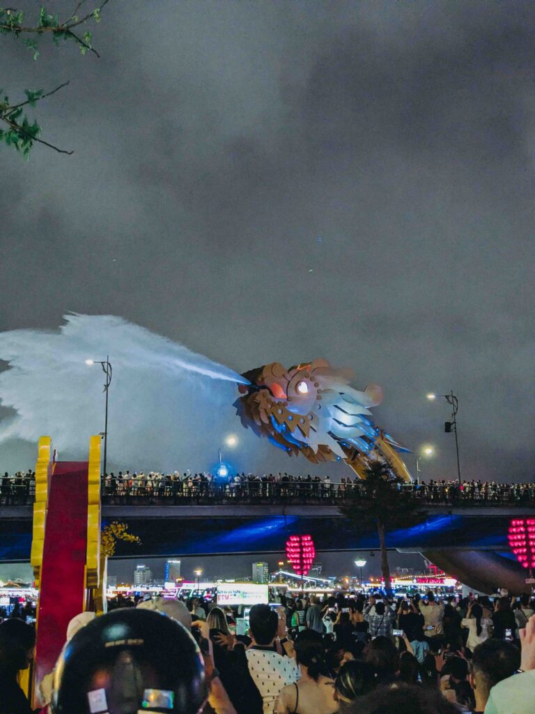 Dragon Bridge Da Nang spraying water during the weekend night show with crowds below