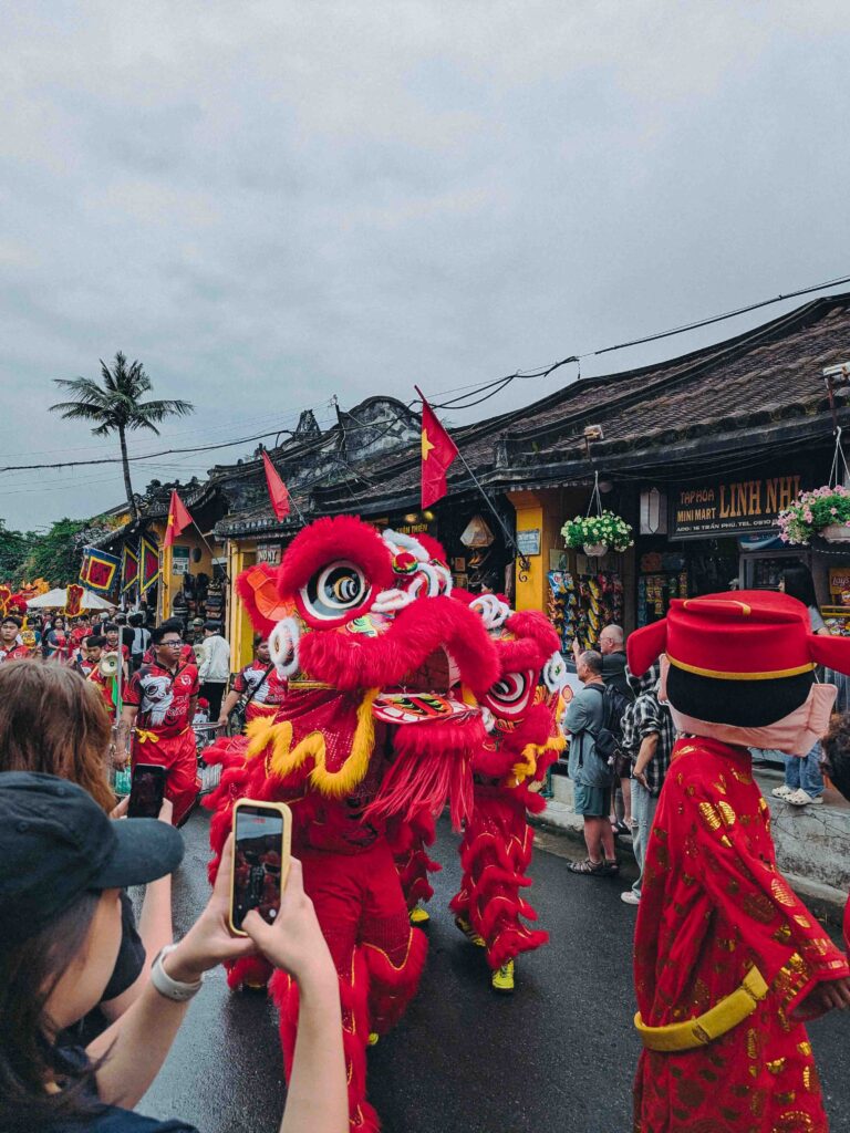 Red lion dance costume parading through Hoi An Old Town streets during the First Full Moon Festival Tết Nguyên Tiêu