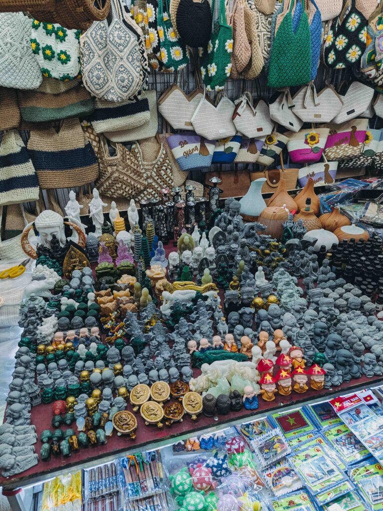 Souvenir stall at Han Market Da Nang covered in Buddha figurines stone statues woven bags and Vietnam keepsakes