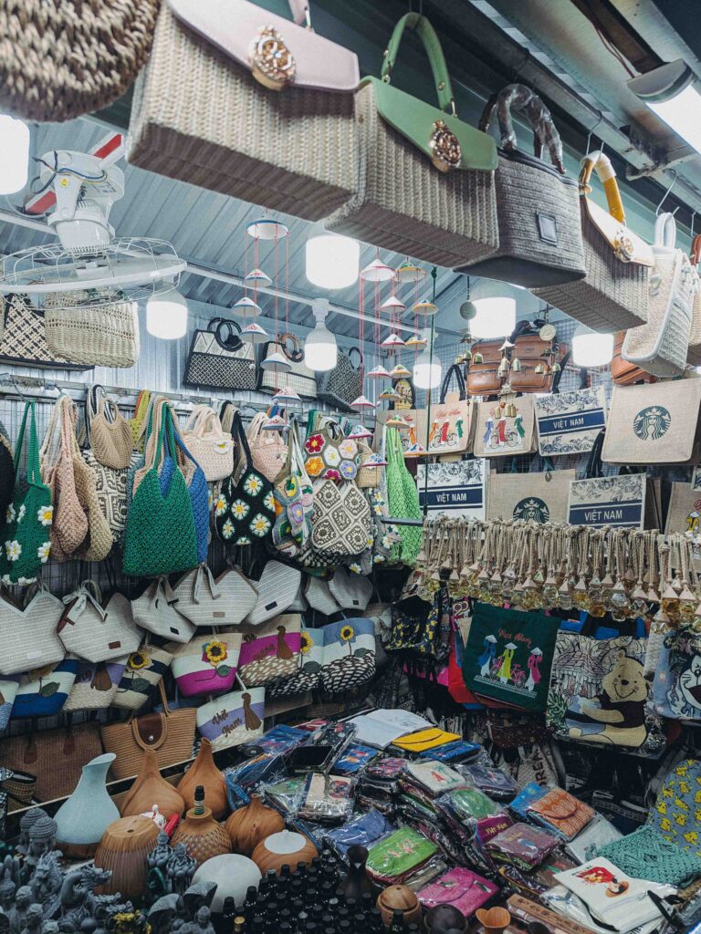 Souvenir stall at Han Market Da Nang packed with woven rattan bags crochet handbags and Vietnam tote bags hanging from ceiling