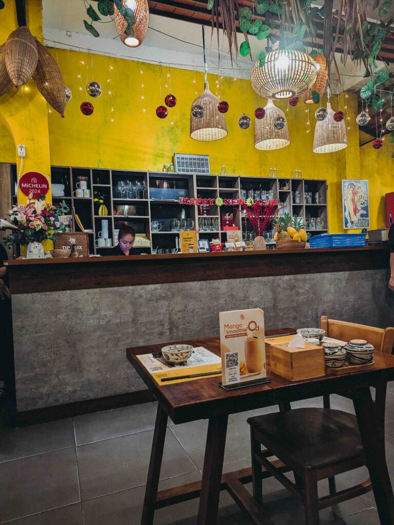 Interior of Ăn Thôi Da Nang showing the service counter with a Michelin 2024 plaque on the wall