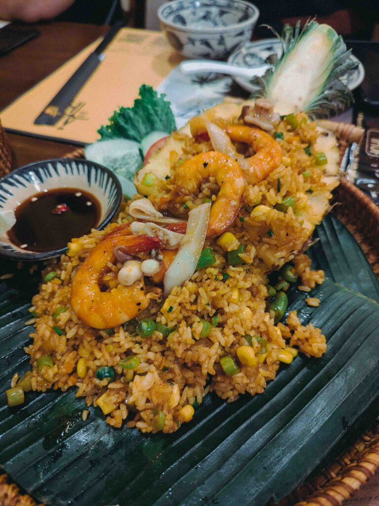 Pineapple seafood fried rice with shrimp and squid served on a banana leaf at Ăn Thôi Da Nang