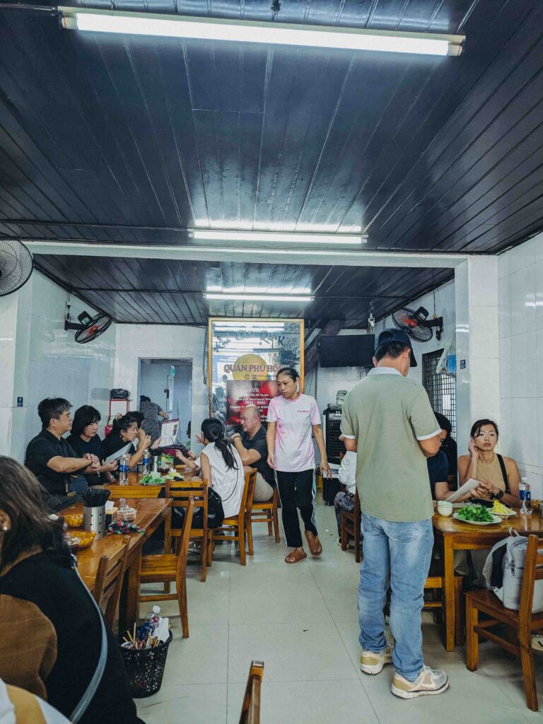 Busy interior dining area at Quán Phú Hồng restaurant in Da Nang with local diners